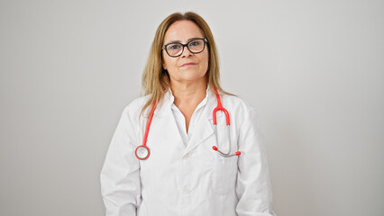 Middle age hispanic woman doctor standing with serious expression over isolated white background