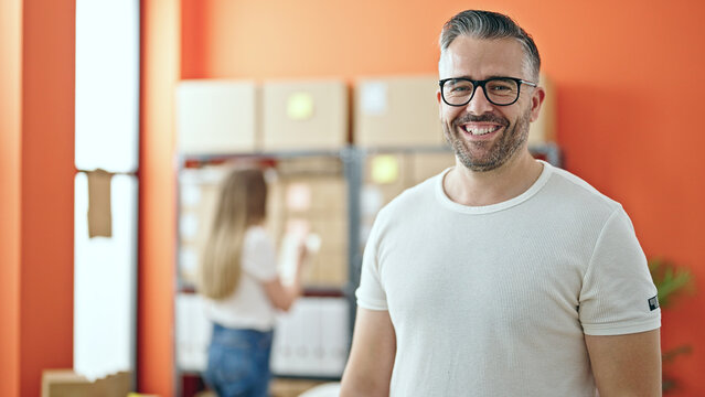 Young Woman And Man Working On Ecommerce Standing At Office