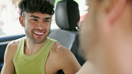 Two men couple smiling confident driving car speaking at street