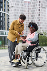 Fototapeta premium Vertical image of couple discussing online software on the phones during their walk outdoors