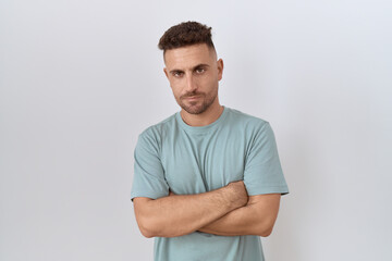 Hispanic man with beard standing over white background skeptic and nervous, disapproving expression...