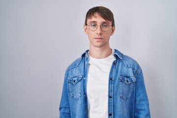 Caucasian blond man standing wearing glasses relaxed with serious expression on face. simple and natural looking at the camera.