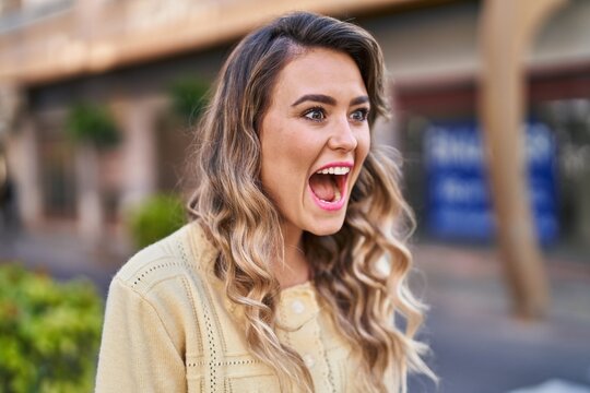 Young woman standing with surprise expression at street