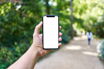 Man holding smartphone showing white blank screen at park