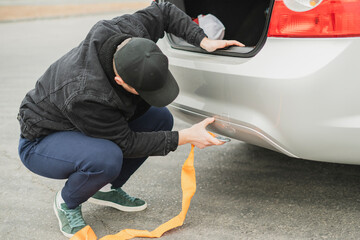 male driver attach the rope to a car's tow hook, car accident