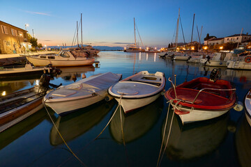Marina with moored boats in the Croatian town of Malinska on the island of Krk in the evening