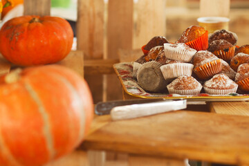 Pumpkin season in vegan cafe concept. Tasty homemade pumpkin muffins served on wooden pallet. Close up. Indoor shot