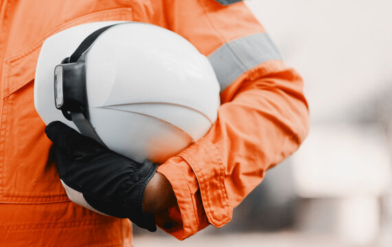 Fit Man Holding Safety Helmet With A Heavy-Duty Light In A Hand Wearing An Orange Uniform - Powered by Adobe
