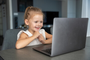 Little girl student online learning, class study online video call with teacher on the laptop home. Distance learning concept.