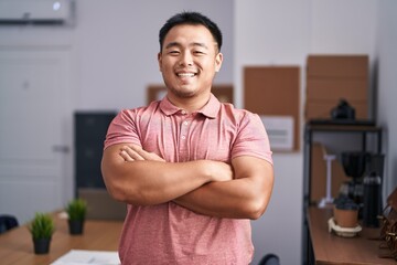 Young chinese man business worker smiling confident standing with arms crossed gesture at office