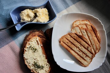 sandwiches from a loaf and with cheese paste on a wooden stand and in a white plate