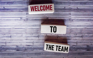 WELCOME TO THE TEAM text concept on wooden blocks on wooden background