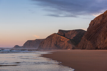 Fototapeta na wymiar Sunset at sandy Cordoama Beach at Atlantic Ocean, Algarve, Portugal
