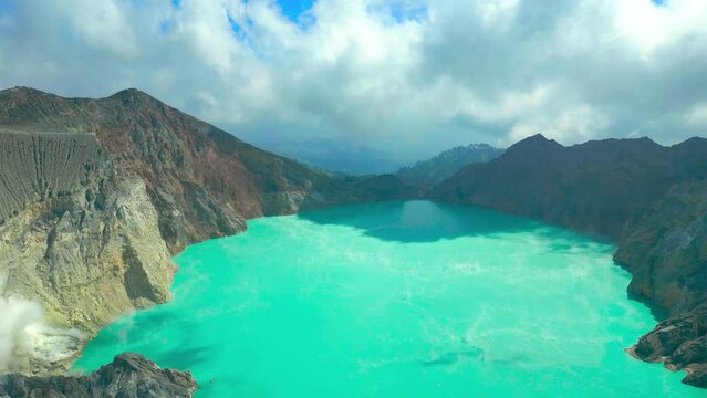 Aerial view on dead tree on the edge of an active volcano Kawah Ijen in the crater of which there is a sulfur lake, East Java, Indonesia.