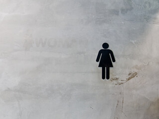 Black Women's Toilet Symbol on Grungy Concrete Wall