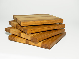 stack of 4 hardwood hand made crafted drinks coasters in oak and maple with felt padded feet isolated on a white background