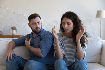 Stressed millennial husband and wife facing conflict, relationship crisis, marriage trouble,...
