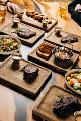 Tasty dishes in restaurant with beef steak, salad and barbecue chicken wings. Food menu concept