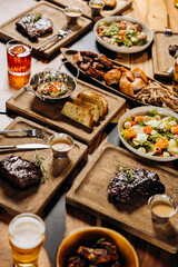 Tasty dishes in restaurant with beef steak, salad and barbecue chicken wings. Food menu concept