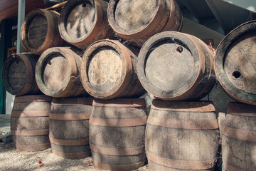 Row of wooden vintage beer barrels lit by sunlight