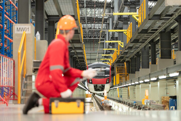 Portrait of engineer using repair tools of the electric train industry There is an electric car in the car repair factory as the background image.