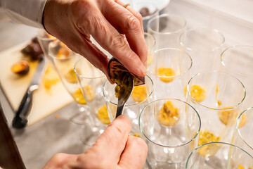 A woman mixes passion fruit into champagne glasses for a cocktail at a birthday party