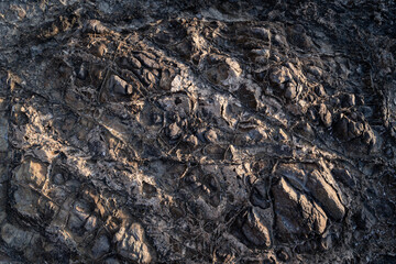 Weathered textured natural rock surface background under sun light