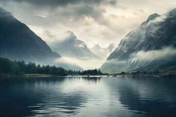Misty mountain peaks overlook a serene, rocky lake.
