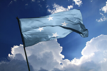 national flag of Micronesia waving in the wind on a clear day. - obrazy, fototapety, plakaty