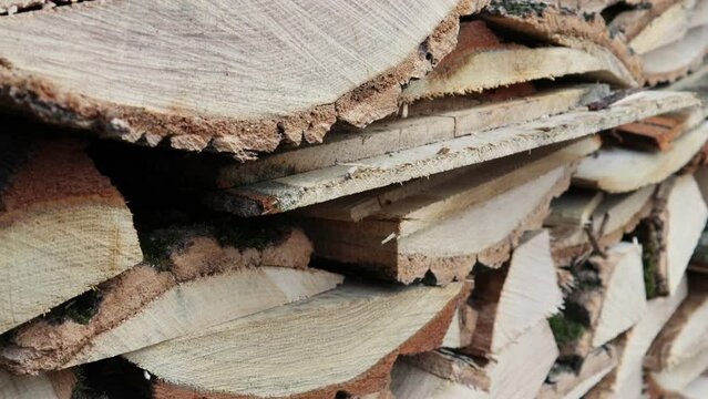 The wood for stoking the stove is stacked in a row. The video shows a beautiful view of the cut wood