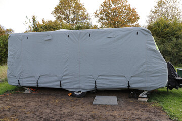 a caravan with a gray tarpaulin