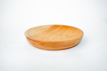 Wooden plate made of wood on white background. Handmade cooking utensils.