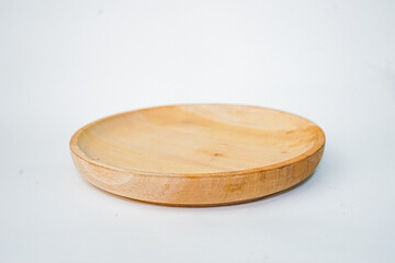 Wooden plate made of wood on white background. Handmade cooking utensils.