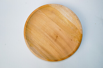 Wooden plate made of wood on white background. Handmade cooking utensils.