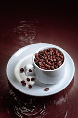 Cup with coffee beans on a brown background.