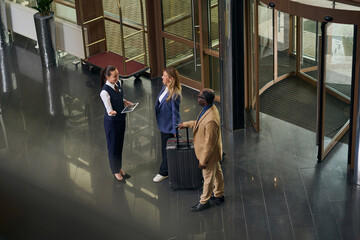 High angle view of manager with digital tablet meeting guests in the hotel