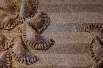 Traditional italian ravioli. Homemade italian pasta.Fresh ravioli on wooden board, top view