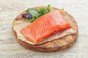 Raw salmon fillet over board