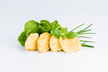 Breaded chicken nuggets.Breaded Chicken Inner Fillet with green lettuce leaves on a White Background.Chicken Breaded Raw Meat,Fillet.Fast homemade food at home. Chicken breaded schnitzels.Fast cooking