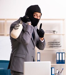 Male gangster stealing information from the office