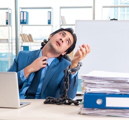 Chained male employee unhappy with excessive work