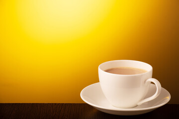 Cup of tea on yellow background with text space