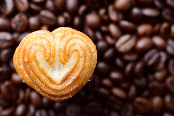 Top view of heart shape cookie on coffee bean background