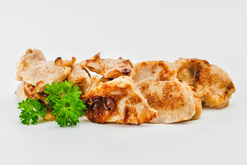 Chicken fillets fried until half cooked, semi-finished product with fresh herbs on a white background. Fast cooking.Fast homemade food.Fast food. Quick cooking at home. Copy space.