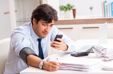 Man under stress measuring his blood pressure