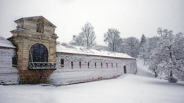Fragment of an old fortress wall in the Polish city of Zamosc during a snowfall. An old Eastern European fortification. Architectural monument. Snowfall.
