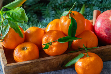 Fresh tangerine fruits or tangerines with leaves in the wooden box