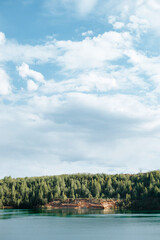 Landscape of lake, forest and sky on a sunny summer day. Vertical view