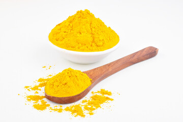 Turmeric powder in spoon on white background