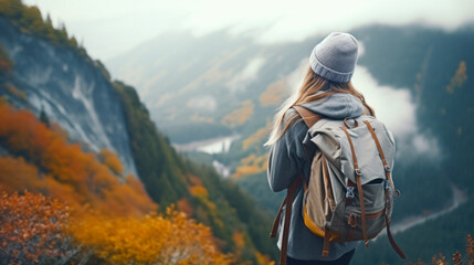 Young woman hiker with a backpack on the background of the mountains.